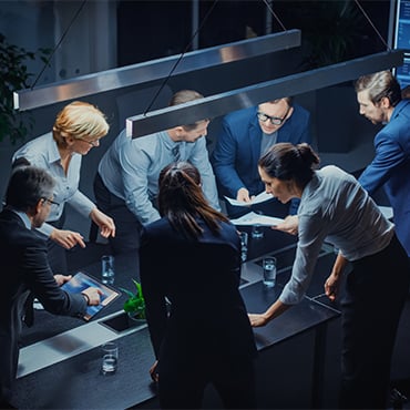 Dark Corporate Meeting Room with Diverse Group of Executives