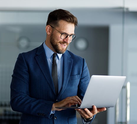 A close up of a business man in a suit using his laptop